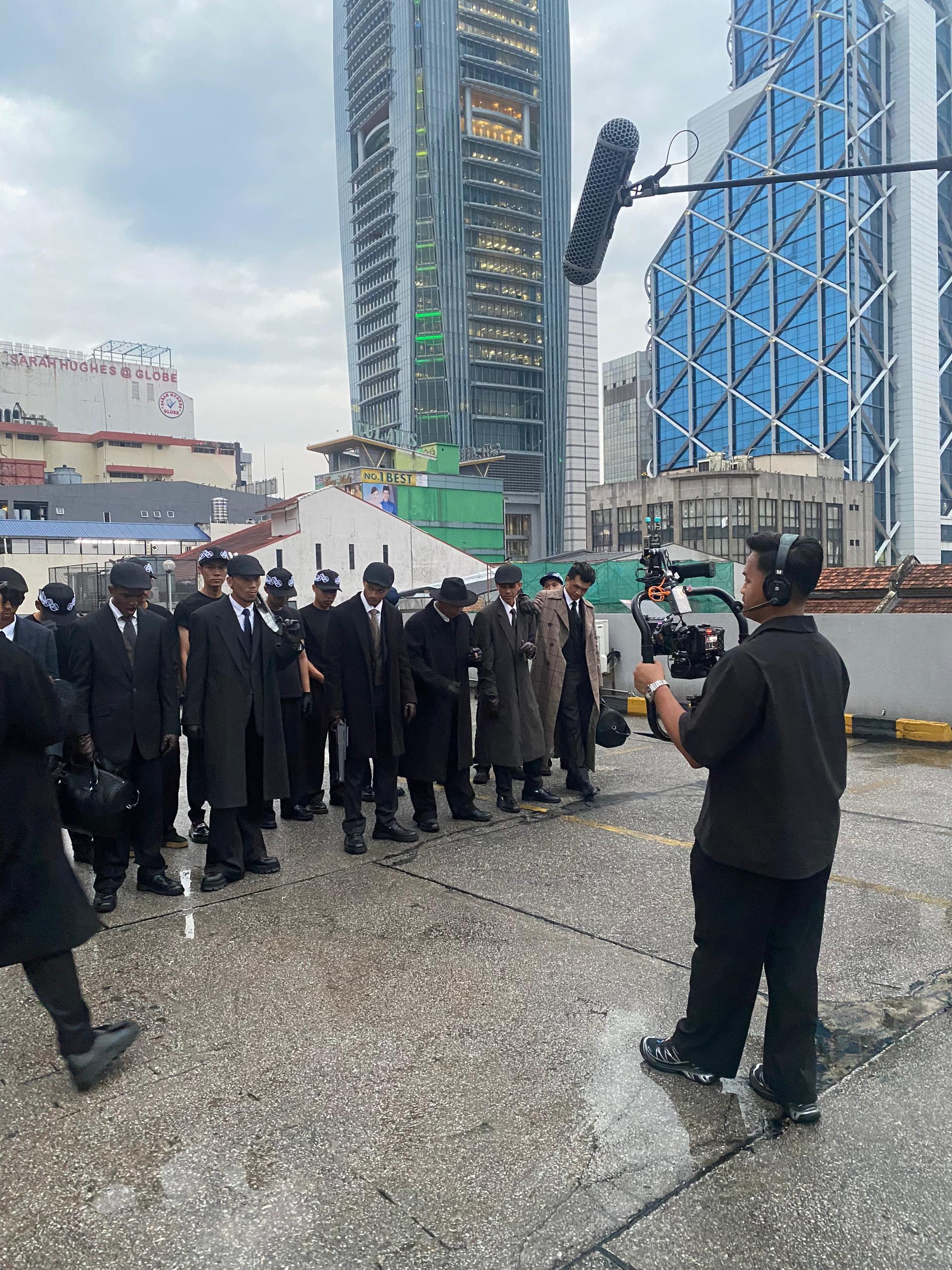 Crew directing models on a rooftop set in Kuala Lumpur
